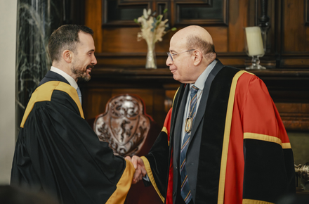 President shaking hands with physician in robes